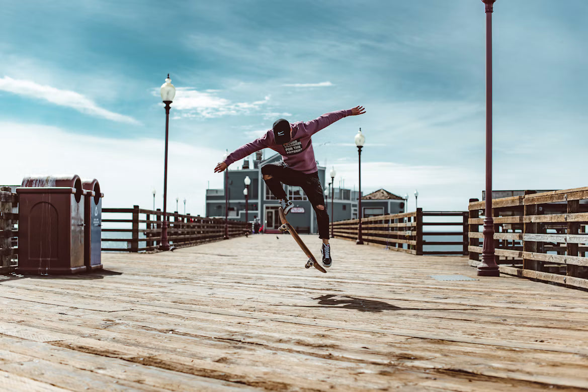 Skateur en plein ollie sur un ponton en bois, la planche décolle sous ses pieds
