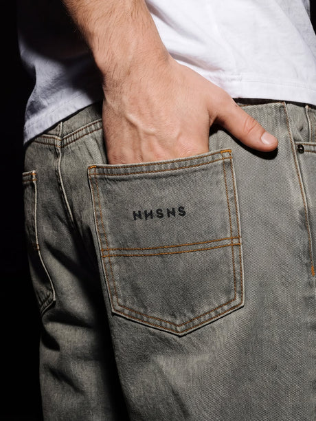 Poche arrière d'un jean baggy Nonsense délavé gris avec le logo NNSNS
