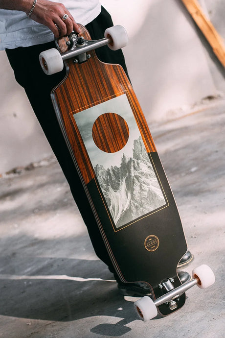 Longboard drop-through Globe en bois tenu à la main, roues blanches